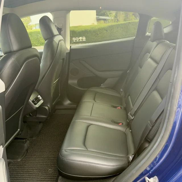 Rear passenger seats and legroom inside the EV Rider Tesla